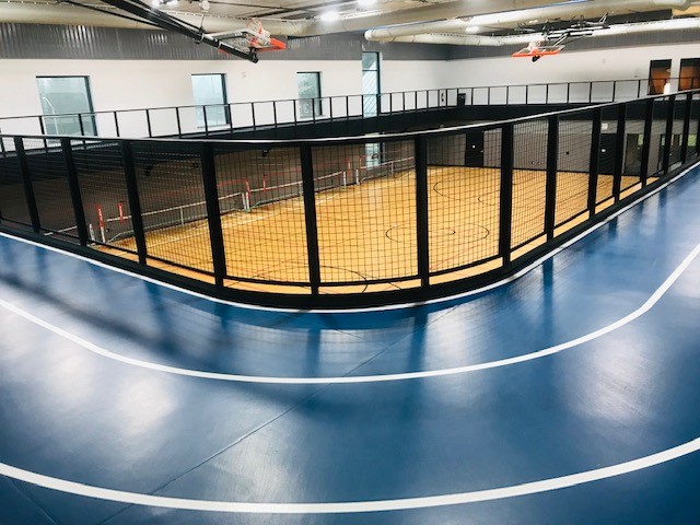 Photo showing the two lane walking track elevated above the court inside the building
